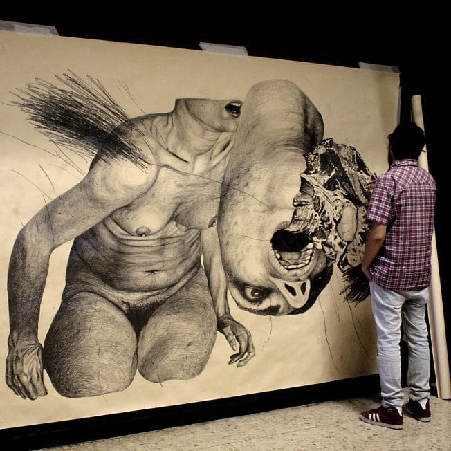 Oeuvre de Nicola Alessandrini - graphite sur papier représentant une femme nue dont la moitié du visage est coupé pour réapparaître à l'envers au premier plan. 