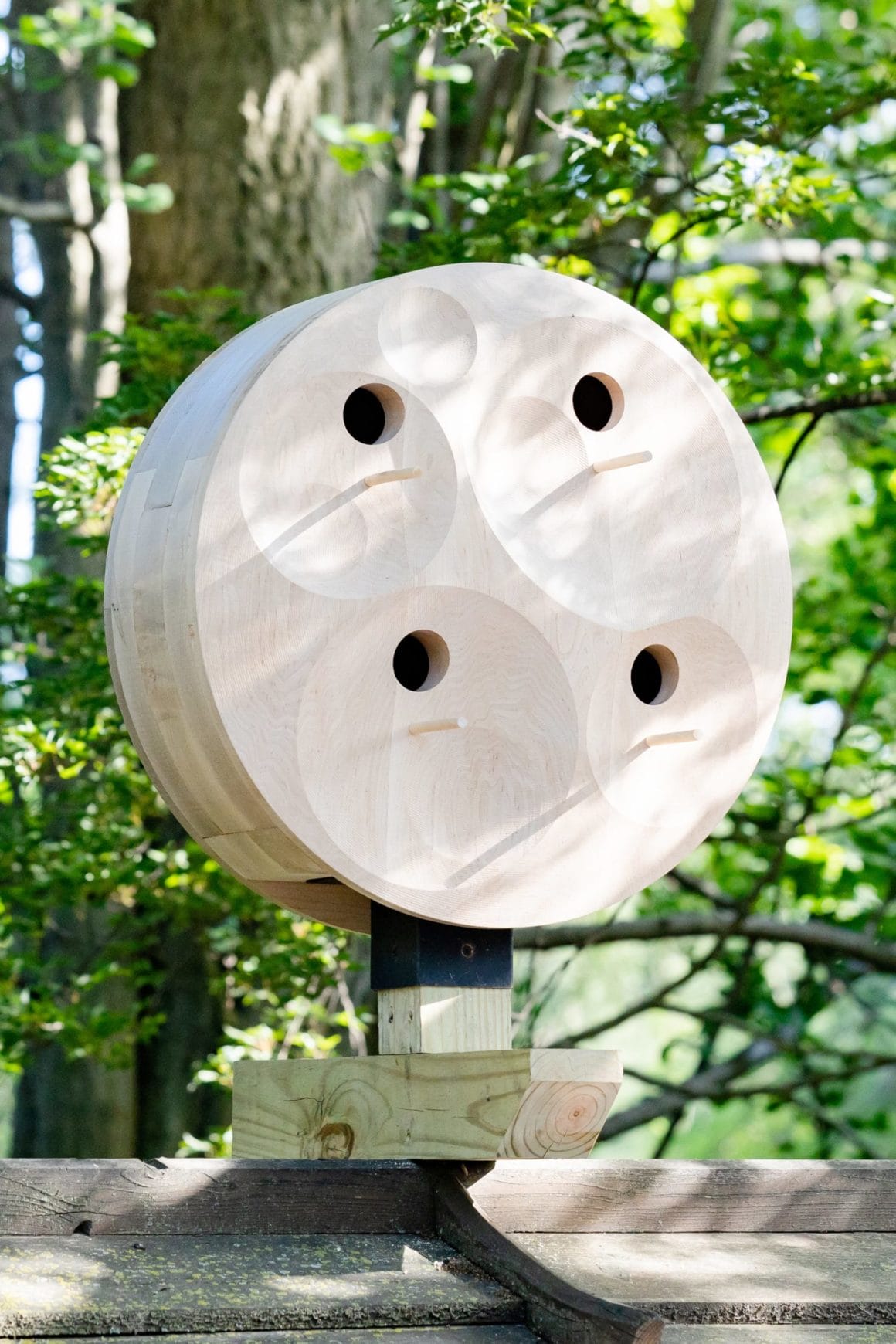 Cet abri est fait en bois avec une forme ronde. Il possède quatre ronds pour permettre aux oiseaux d'entrer, et en-dessous des ronds se trouve des bâtons pour que les oiseaux puissent s'installer dessus.