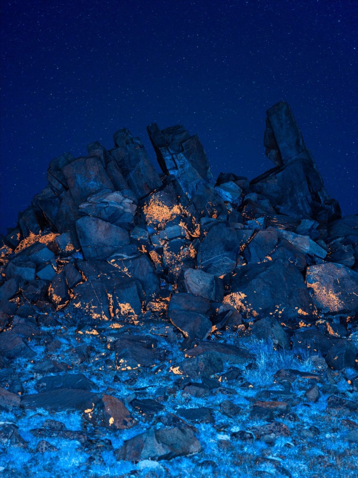 Ces rochers se retrouvent couverts d'une matière orange et les plantes en dessous sont bleues.