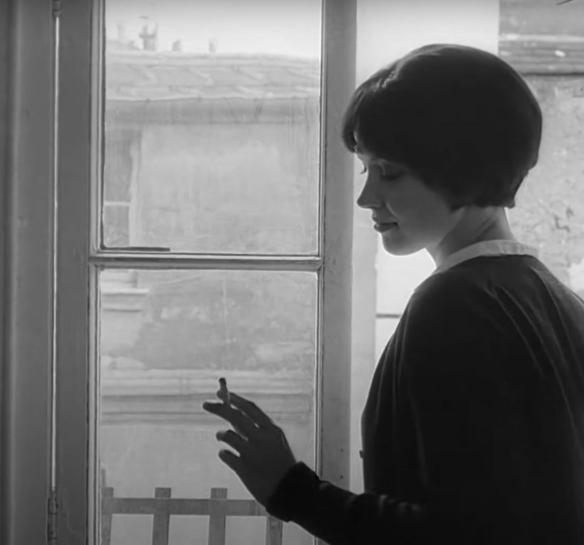 L'élégante Anna Karina fume une cigarette à la fenêtre dans le film "vivre sa vie"