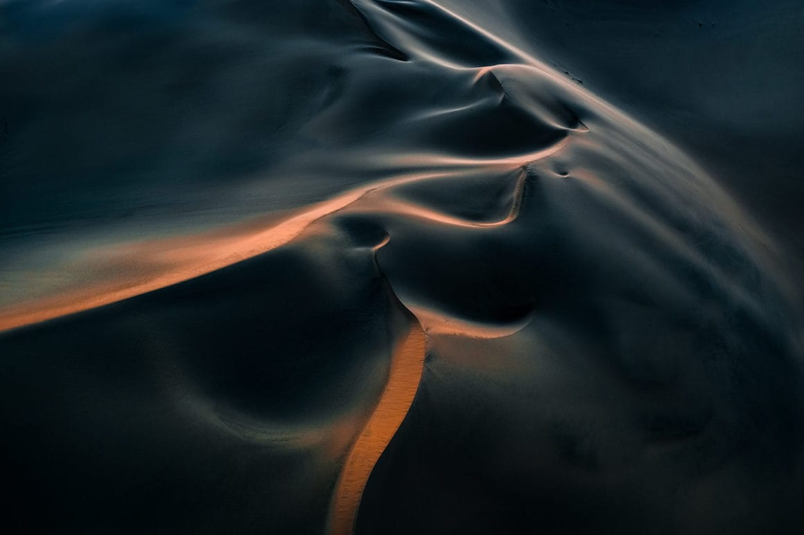 Dunes de sable de Namibie aux allures très lisses de couleurs oranges et bleutées.