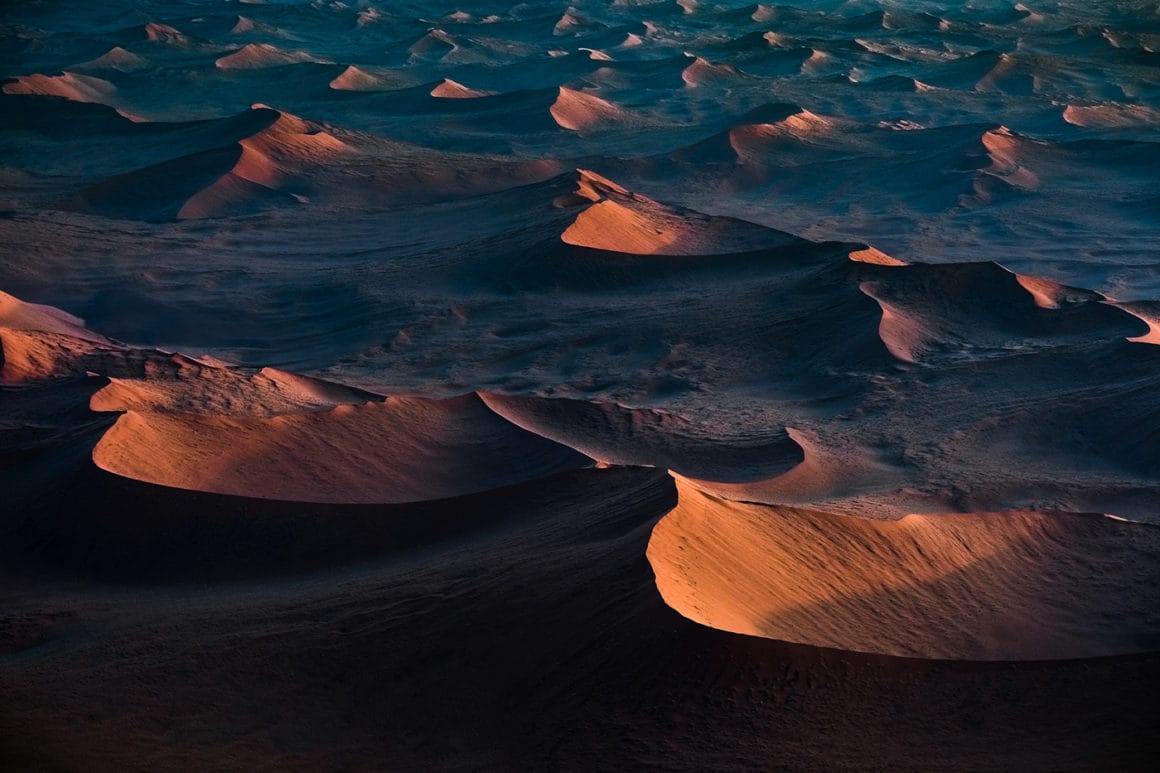 Des dizaines de montagne de Namibie sont éclairées par le couché de soleil.