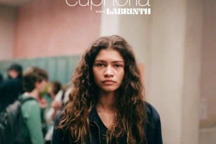 Affiche de la série Euphoria Zendaya se tient devant la caméra dans un couloir de lycée le visage sans émotion.