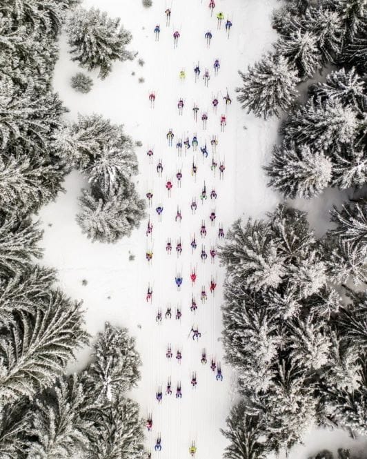 Photo aérienne de skieurs descendant une piste enneigée.