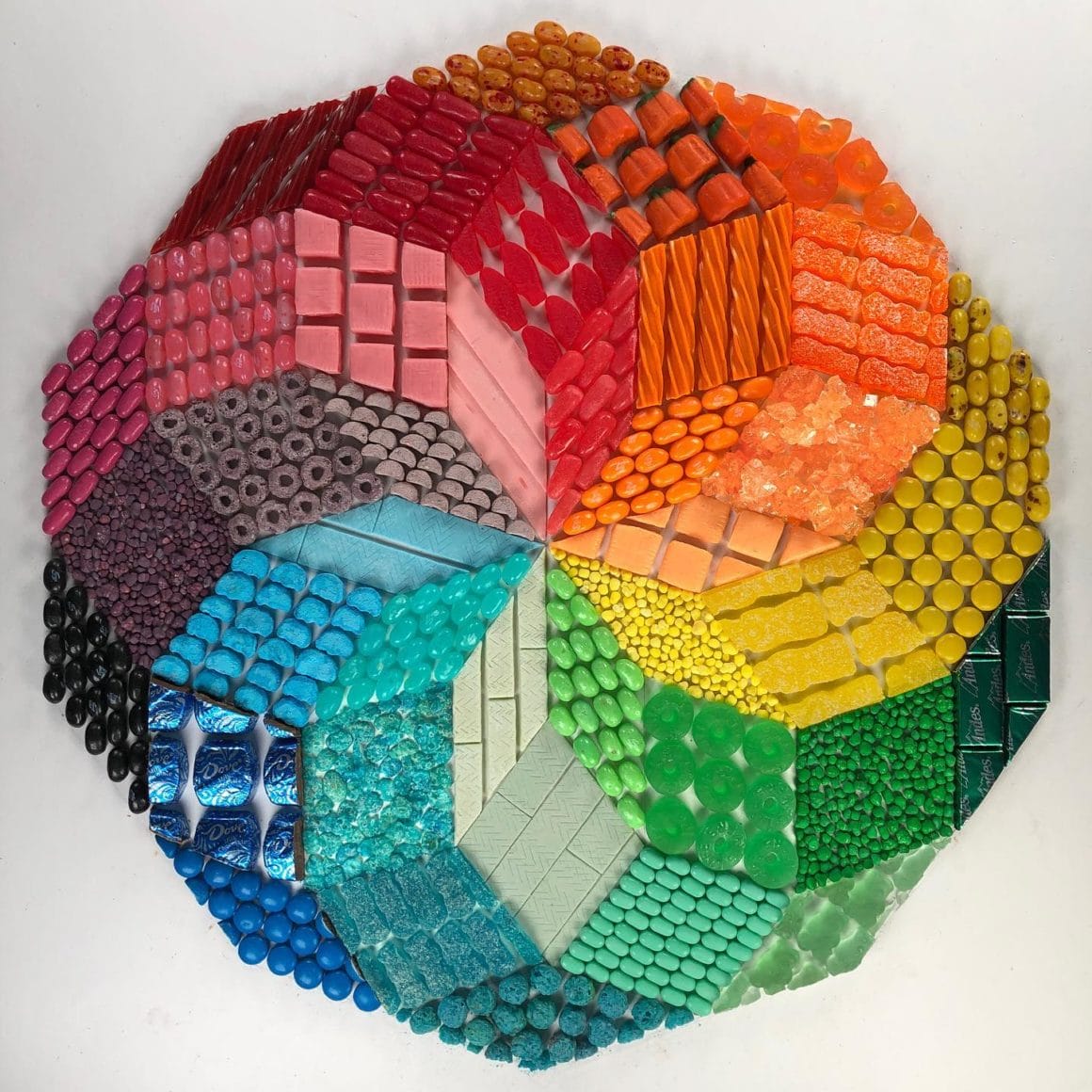 Oeuvre illusionniste représentant une rosace multicolore réalisée avec des bonbons
