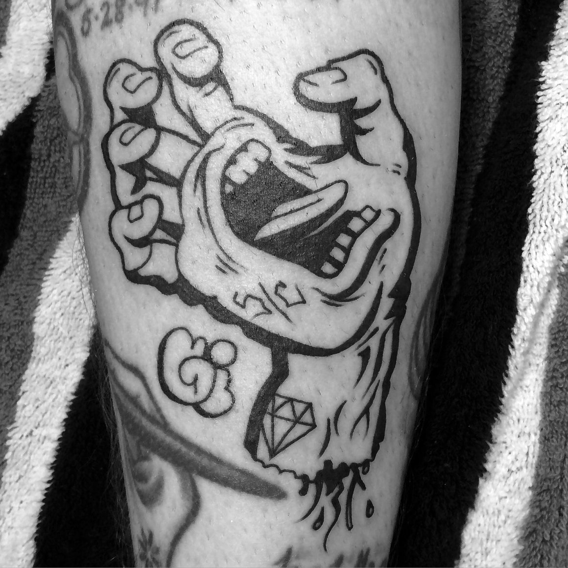Photographie d'un tatouage de Mike Giant, une main possédant une bouche en train de crier.