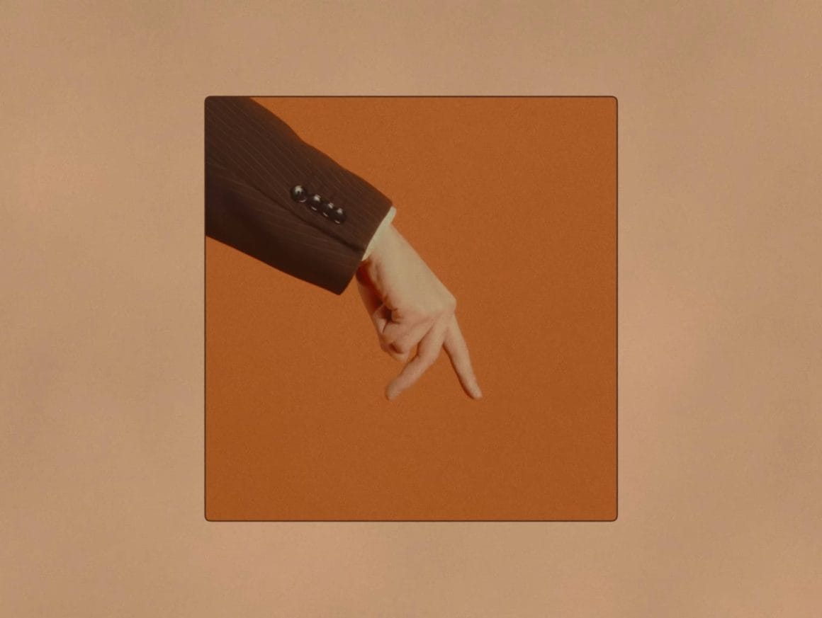 main dans un cadre orange faisant "marcher" deux de ses doigts