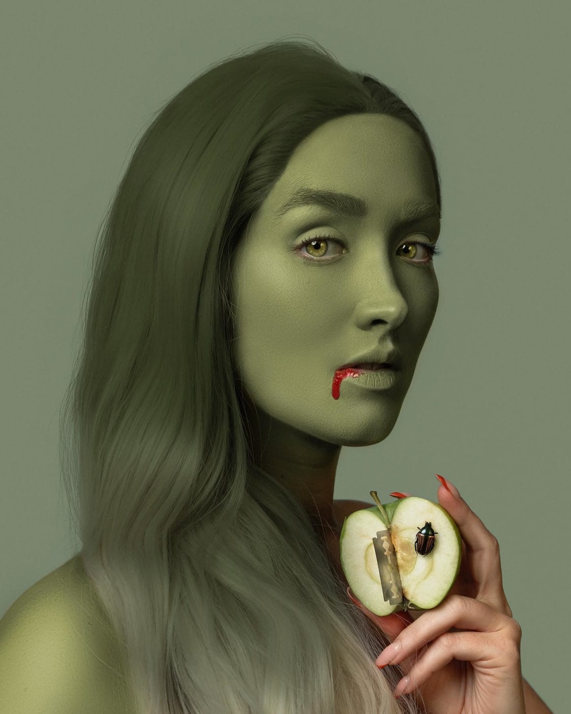 artiste avec une pomme et un filet de sang sur la bouche