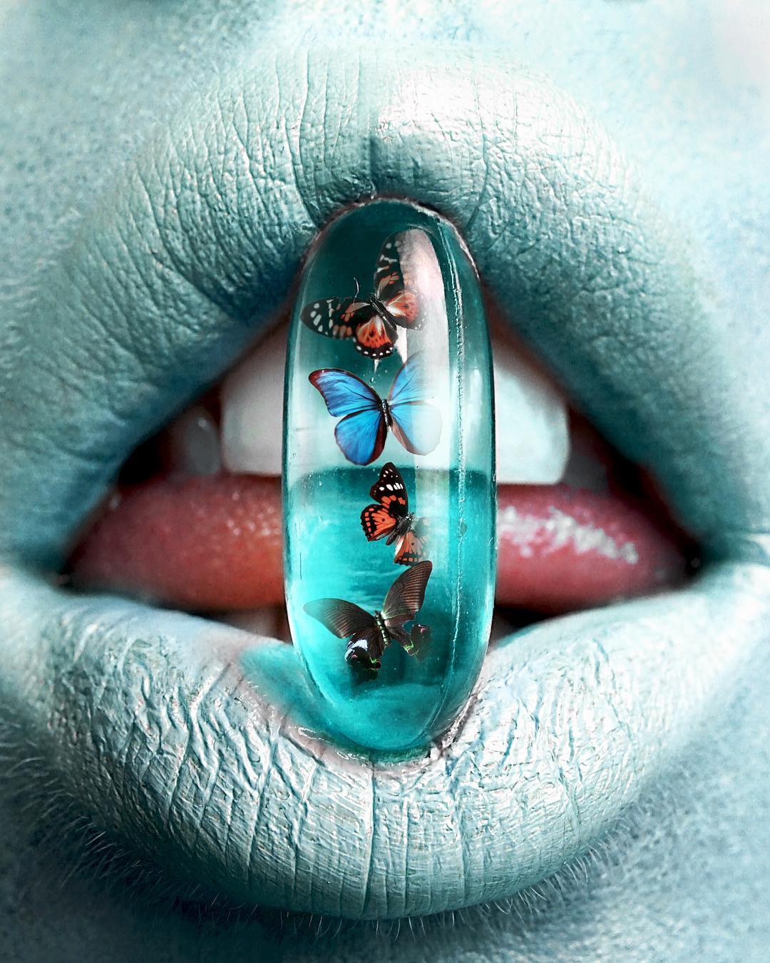 bouche bleue prête à avaler une pilule remplie de papillons