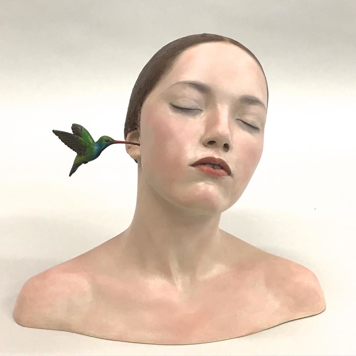 femme avec un colibri dans l'oreille