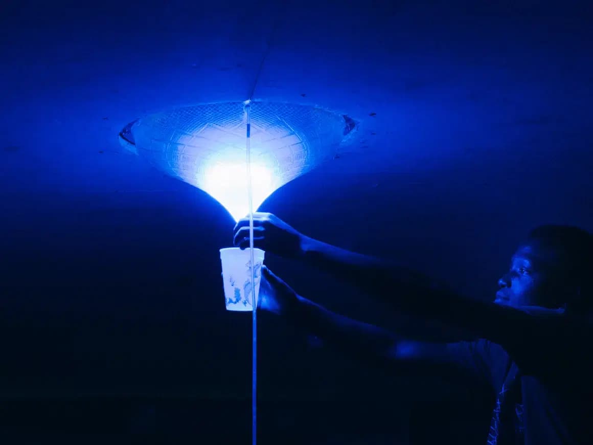 Un homme récupère de l'eau potable provenant de la lampe solaire.
