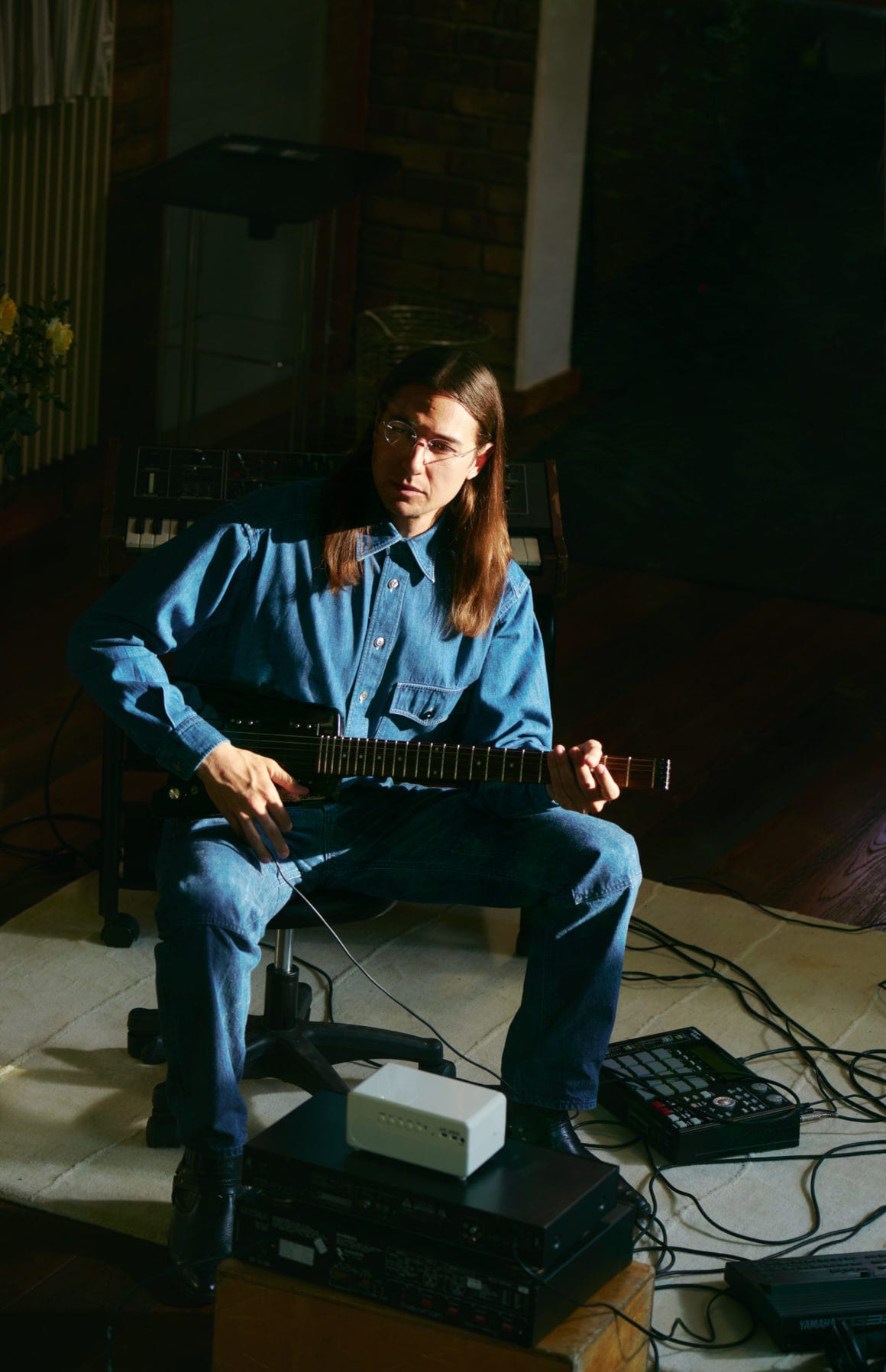 Photographie portrait de Saint DX, guitare à la main 