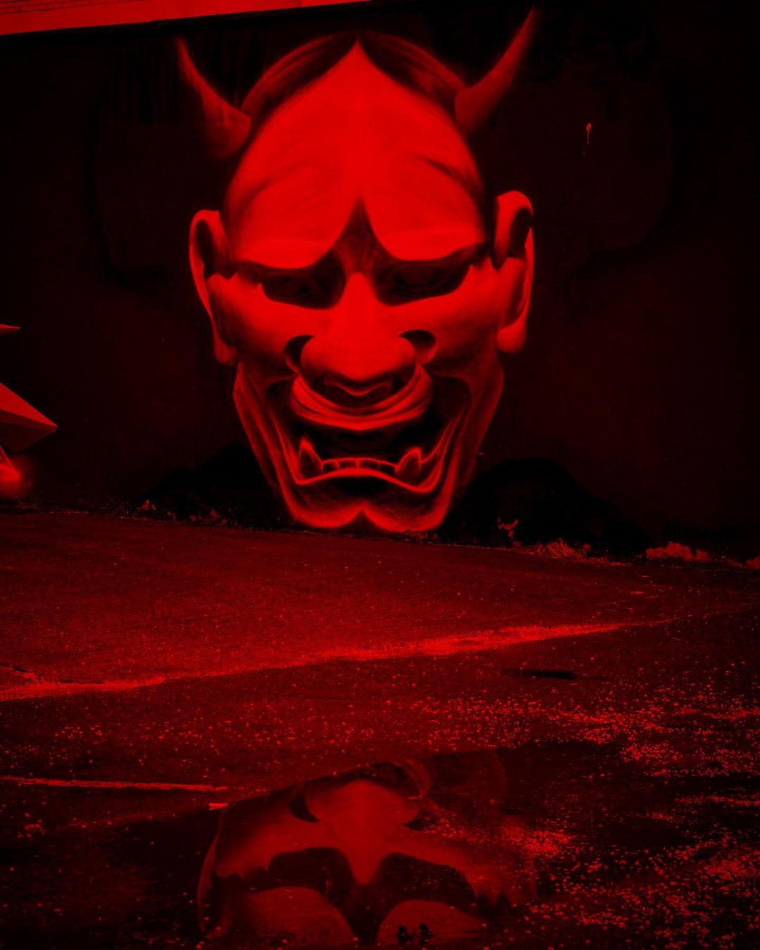 Un masque terrifiant se découvre avec le rouge de l'oeuvre