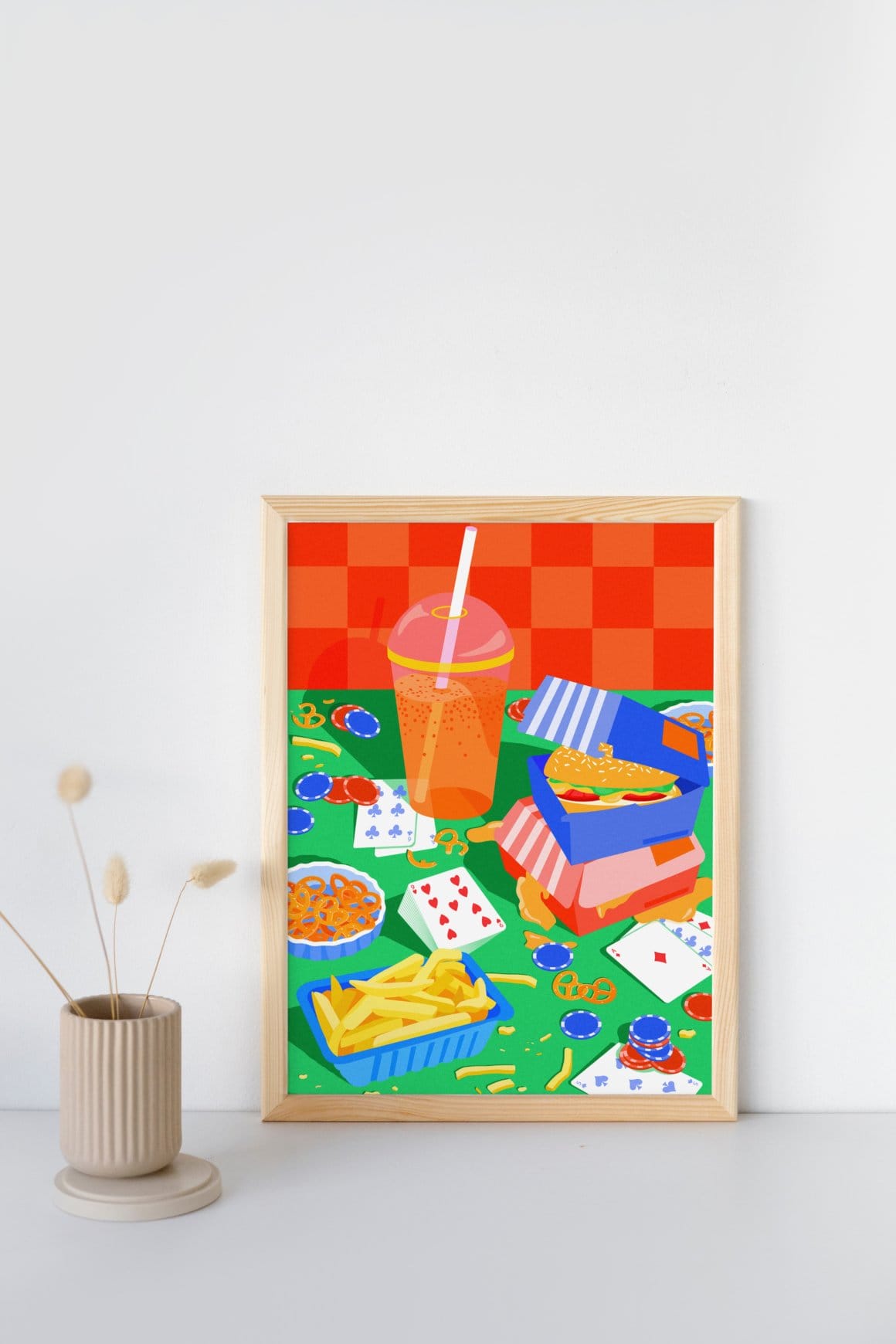 Photographie d'une illustration encadrée, avec plusieurs éléments colorés (frites, jeu de cartes, hamburgers etc.) 
