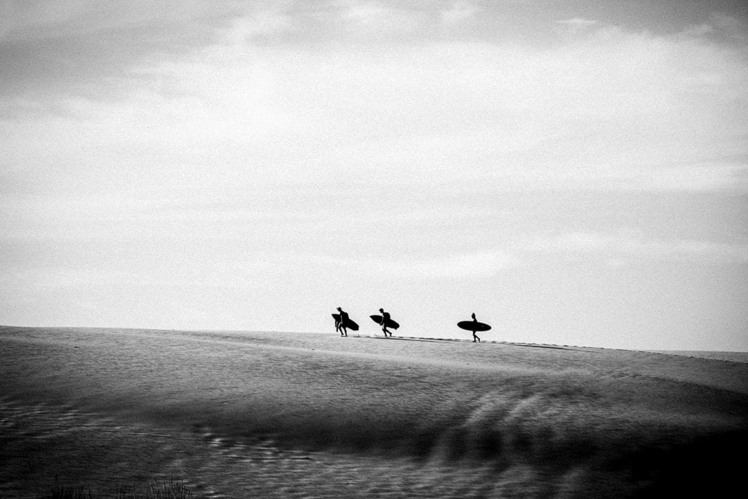 Photo en noir et blanc de surfeurs issue de la série 'Soleil Froid' de Thomas Meurot