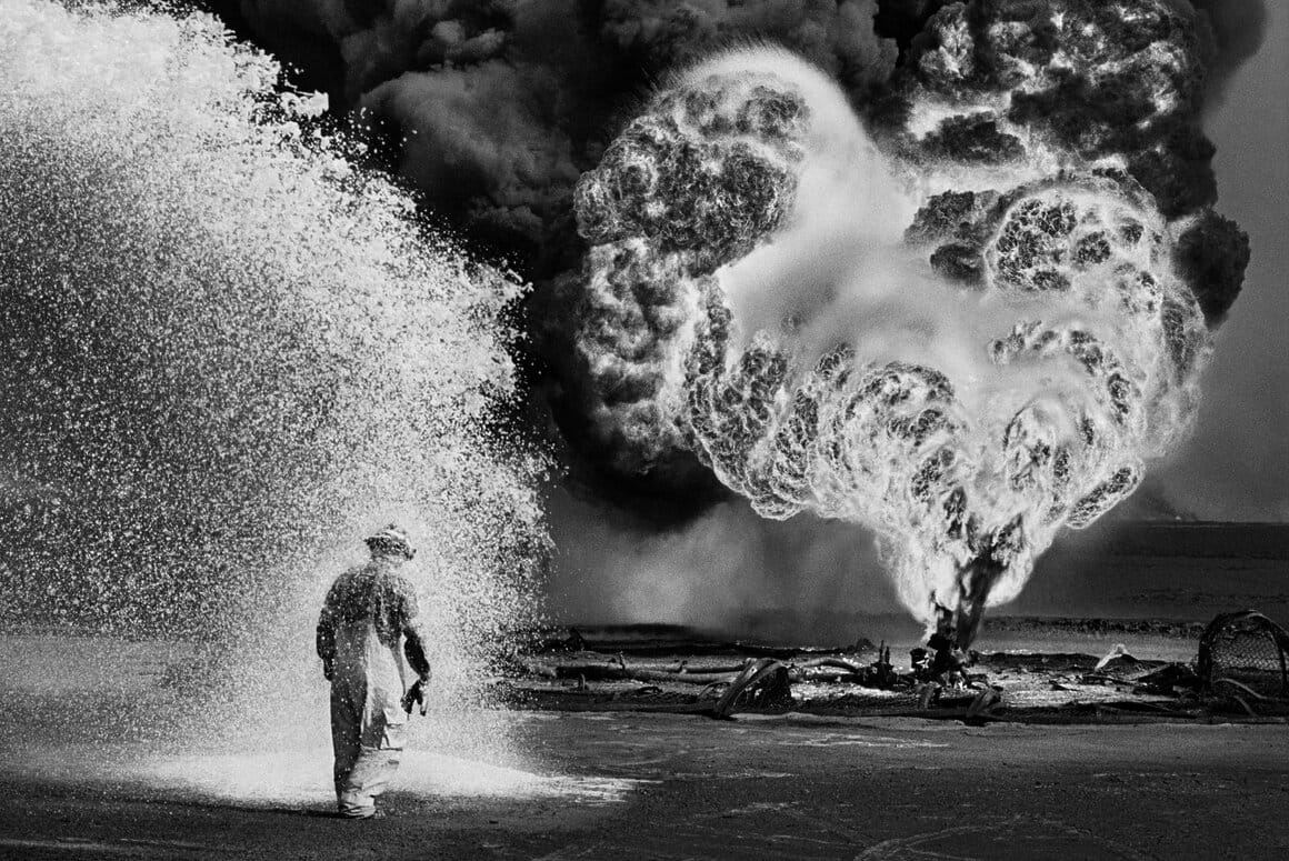 Ce combattant du feu est protégé de la température extrême des flammes par la vaporisation diffuse de produits chimiques. Gisement de pétrole du Grand Burhan, Koweit, 1991.