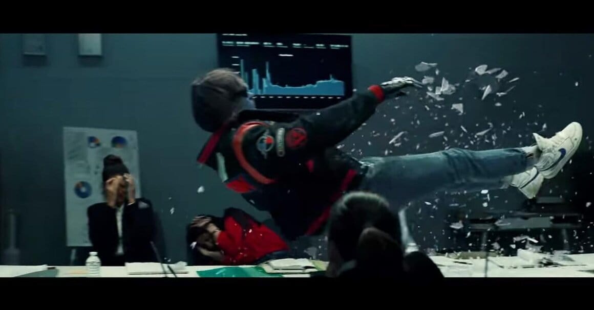 Un homme est projeté à travers une vitre dans une scène d'action issue d'un clip de Kavinsky.