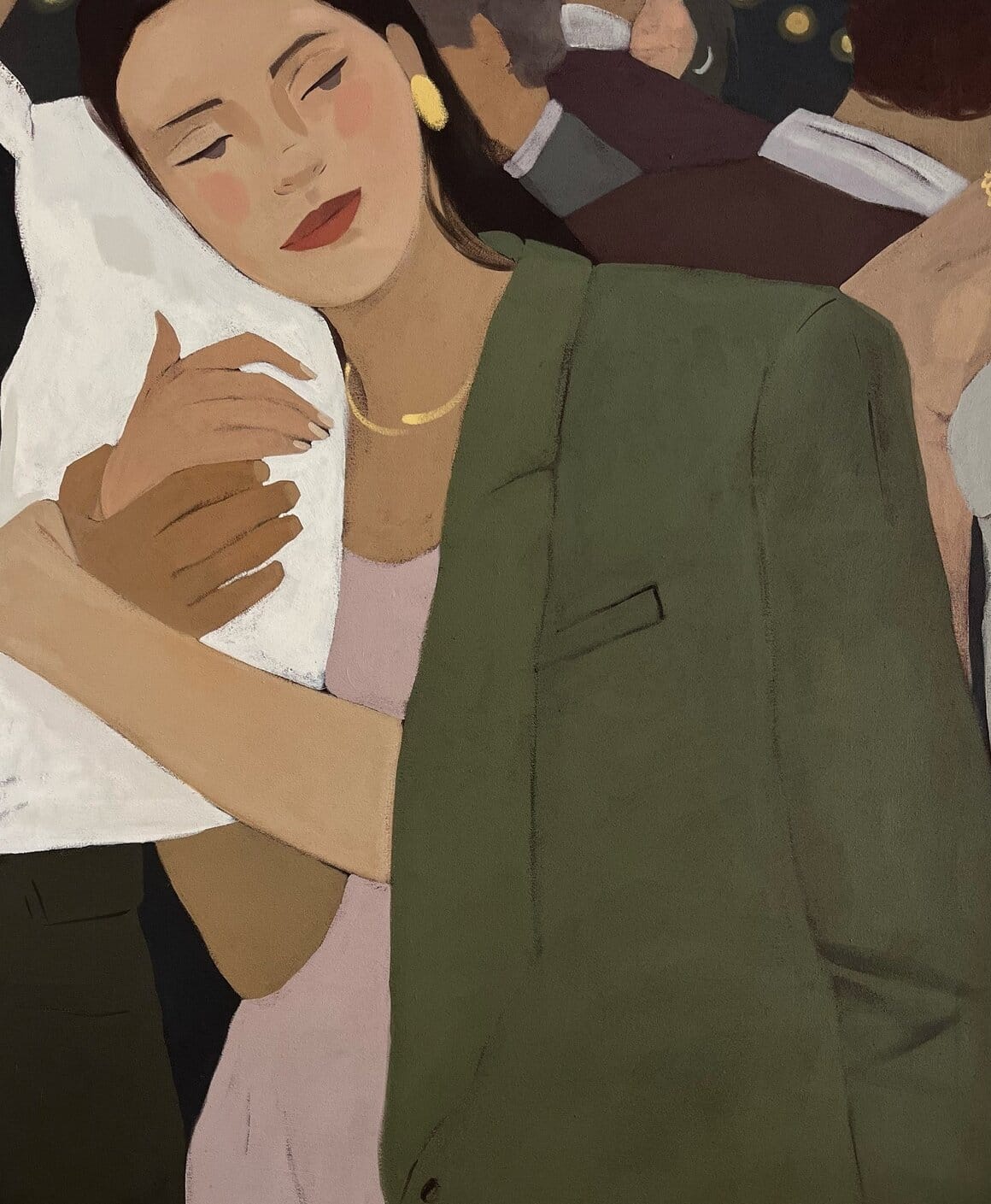 Une femme au regard dans le vide, vêtue d’un haut rose,est au bras de quelqu'un.