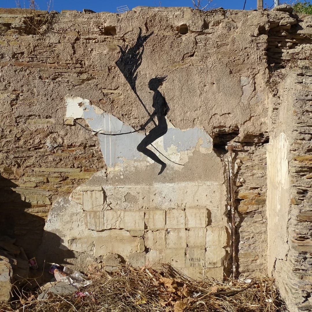 Fresque réaliser par la street artiste David de la mano. "Las invisibles de pizarrales" représente une silhouette féminine portant un drapeau et chevauchant un cheval dont la silhouette est elle créer à partir des dégats du mur