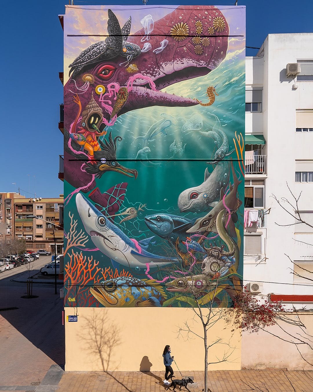 Œuvre réalisé par l'artiste Dulk. La fresque représente des animaux marins en spirale. Il y a une raie, des poissons, un mérou, un requin ble, des oiseaux marins, une tortue et un cachalot violet dont la queue est séctionnée.