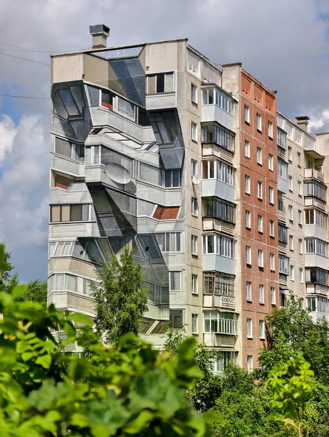 Fresque murale réalisé par l'artiste Shozy. La fresque imite les autres murs de l'immeuble mais modifie le relief en donnant l'illusion que la façade est fragmenté avec des bouts de l'immeuble qui dépassent.