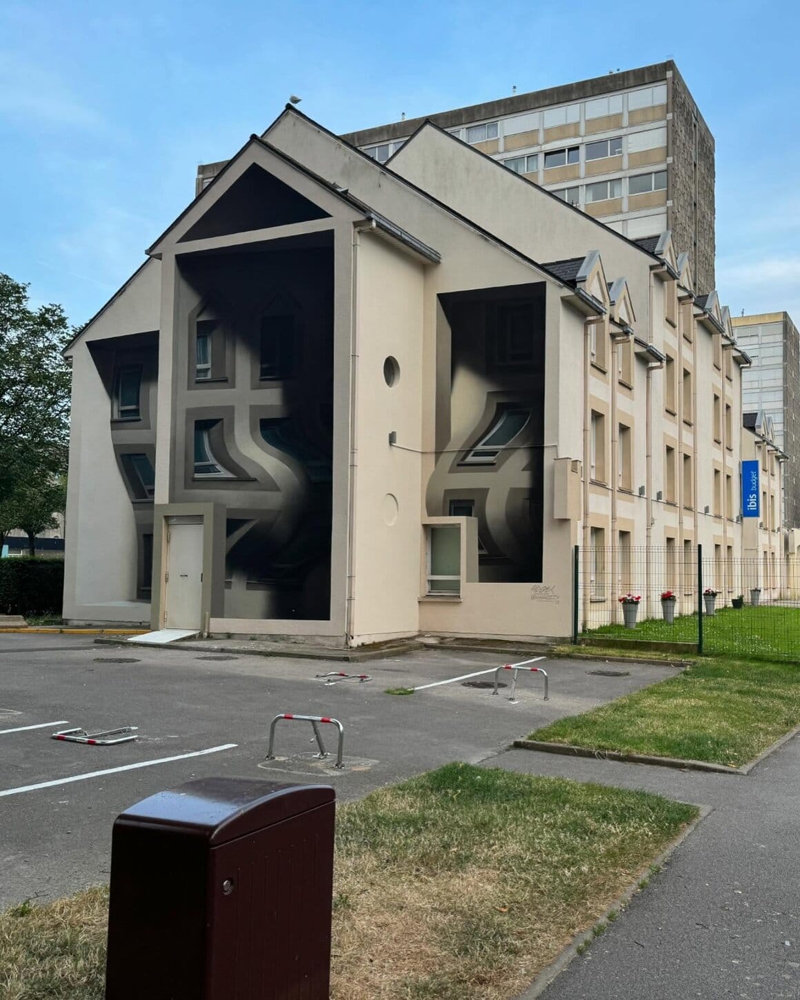 Fresque murale réalisé par l'artiste Shozy. La fresque imite les autres murs de l'immeuble mais modifie le relief en donnant l'illusion que les parties du mur où sont les fenêtres sont ondulés.